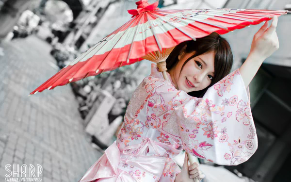 Smiling Taiwanese woman Julie Chang in traditional national dress holds a red umbrella, captured in a vibrant 4K Ultra HD desktop wallpaper background.