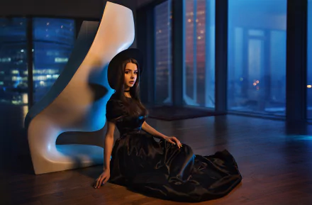 Russian woman model in a black dress and hat poses at night indoors with city lights visible through large windows, captured in HD for a desktop wallpaper background.