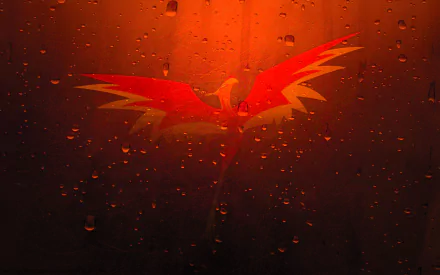 A vibrant phoenix with striking red and yellow wings emerges against a fiery orange background, adorned with glistening droplets, creating a captivating fantasy-themed desktop wallpaper.