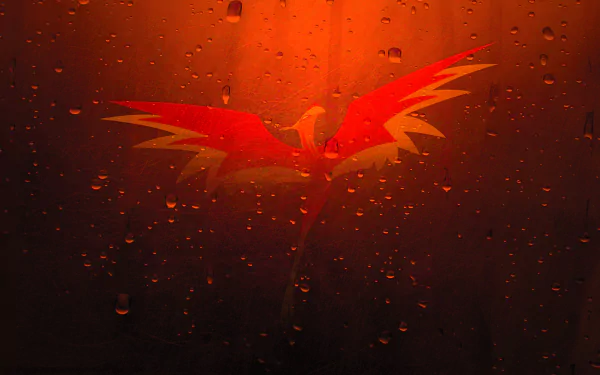 A vibrant phoenix with striking red and yellow wings emerges against a fiery orange background, adorned with glistening droplets, creating a captivating fantasy-themed desktop wallpaper.