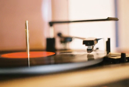 HD desktop wallpaper of a close-up record player spinning a vinyl record, capturing the essence of music and vintage sound.