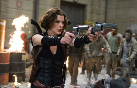 Milla Jovovich wields dual handguns in a tense scene from *Resident Evil: Afterlife*, surrounded by flames and zombie adversaries, showcased in this HD desktop wallpaper.