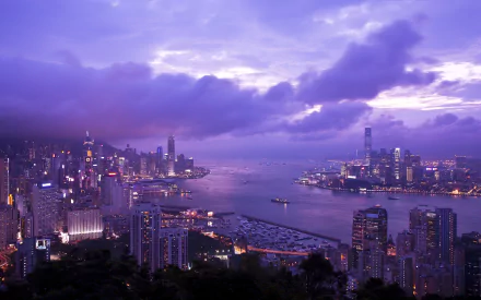 A stunning view of Hong Kong's Victoria Harbour at dusk, featuring towering skyscrapers, dramatic clouds, and a serene sky, captured in vibrant HD quality.
