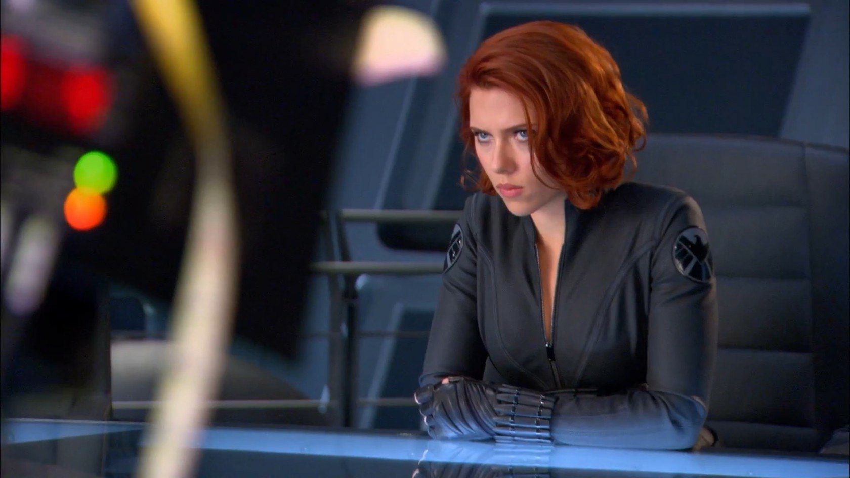 Scarlett Johansson as Black Widow in a gripping scene from the Avengers movie, showcasing her intense expression and agile persona in a sleek, modern setting.