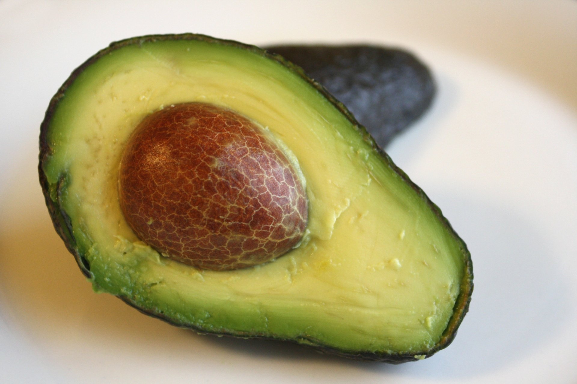 Close-up of a fresh avocado half with the seed visible, captured in 4K Ultra HD quality for a vibrant PC desktop wallpaper background.