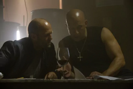 Jason Statham as Deckard Shaw and Vin Diesel as Dominic Toretto share a moment in this HD wallpaper from the movie Furious 7, set in a dimly lit scene with a glass of wine.
