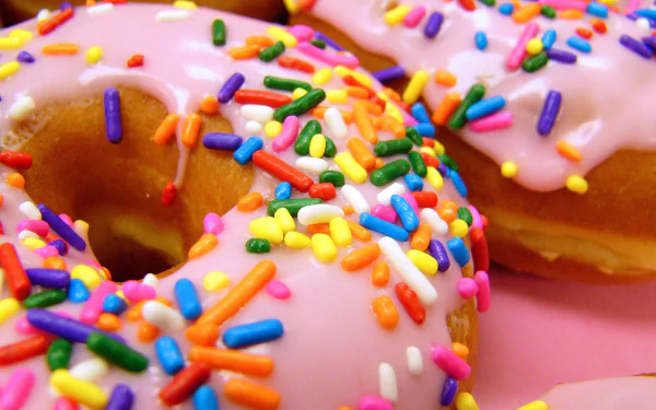 HD PC desktop wallpaper: close-up of pink-glazed doughnuts (dougnut) with rainbow sprinkles on a pink background — colorful food image.