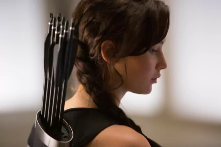 Profile of Jennifer Lawrence as Katniss Everdeen from The Hunger Games, featuring her quiver of arrows in an HD PC desktop wallpaper background.