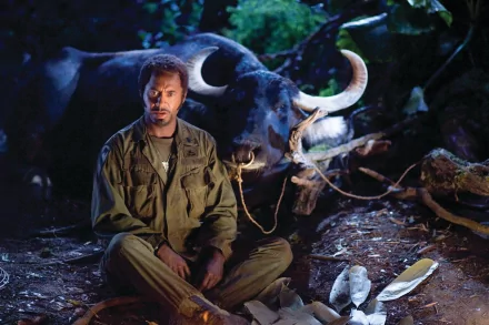 Robert Downey Jr. sitting beside a tied buffalo in a jungle scene from the movie Tropic Thunder, captured in a high-definition desktop wallpaper.