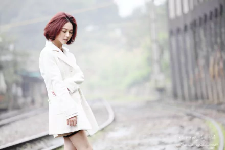 Taiwanese model Lín Yǔ stands thoughtfully by a railroad track, captured in soft focus with a serene and moody atmosphere in this 4K Ultra HD desktop wallpaper.
