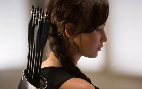 Profile of Jennifer Lawrence as Katniss Everdeen from The Hunger Games, featuring her quiver of arrows in an HD PC desktop wallpaper background.
