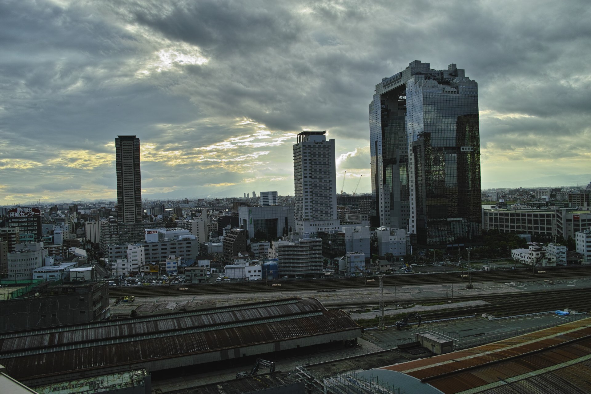 8K Ultra HD view of man-made skyline in Osaka, Japan with dramatic cloud-filled sky above the cityscape.