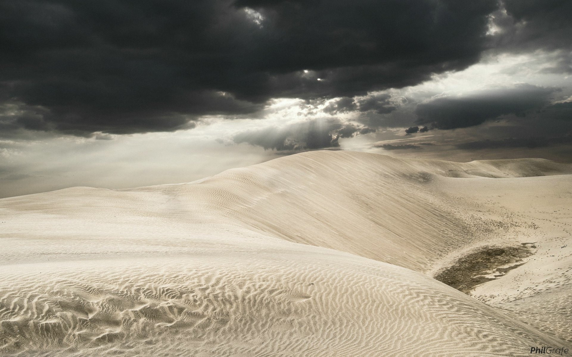 HD PC desktop wallpaper featuring expansive desert sand dunes under a dramatic cloudy sky, showcasing the raw beauty of nature.