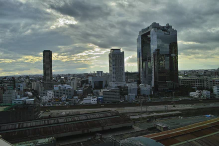 A dramatic skyline view of Osaka, Japan, featuring tall buildings beneath a cloudy sky, captured in stunning 8K Ultra HD. Ideal for those appreciating man-made urban landscapes.