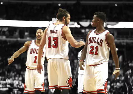 Chicago Bulls players Derrick Rose, Joakim Noah, and Jimmy Butler celebrate on the court. This HD wallpaper captures a dynamic moment in NBA sports history.