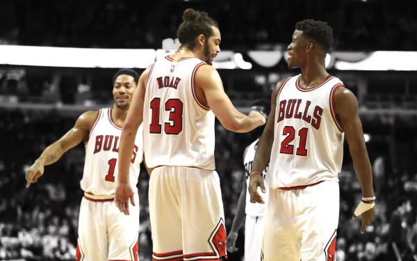 Chicago Bulls players Derrick Rose, Joakim Noah, and Jimmy Butler celebrate on the court. This HD wallpaper captures a dynamic moment in NBA sports history.