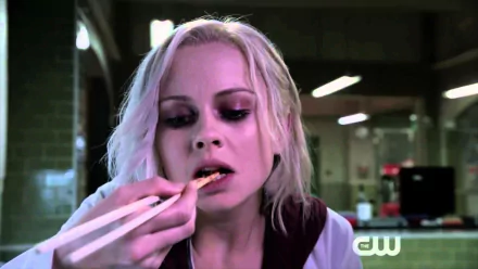 HD PC desktop wallpaper from the TV show iZombie featuring a close-up of a woman with pale skin and blonde hair eating with chopsticks in a dimly lit setting.
