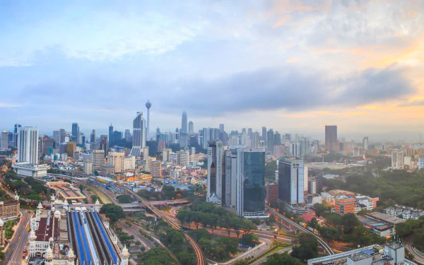 A panoramic view of Kuala Lumpur, showcasing its impressive skyline and urban landscape, with man-made structures against a colorful sky. Enhanced for HD desktop wallpaper use.