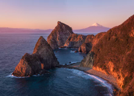Sunset view of the rugged coastline in Matsuzaki-cho, Shizuoka Prefecture, Japan, with Mount Fuji visible in the background in this 8K Ultra HD nature wallpaper.