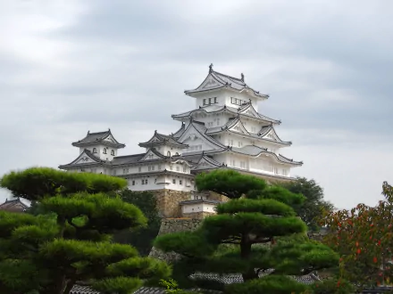 Himeji Castle, a stunning man-made structure in Japan, showcases intricate architecture surrounded by lush greenery under a cloudy sky. This 4K Ultra HD image serves as a captivating desktop background.