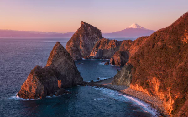 Sunset view of the rugged coastline in Matsuzaki-cho, Shizuoka Prefecture, Japan, with Mount Fuji visible in the background in this 8K Ultra HD nature wallpaper.