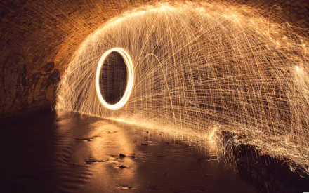 HD desktop wallpaper capturing a spectacular display of fireworks creating sparkles around a wheel in a tunnel with water reflections.