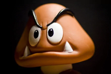 Close-up of a Goomba from the Mario video game series, featuring its iconic frown and expressive eyes. This HD wallpaper adds a playful touch to any desktop background.