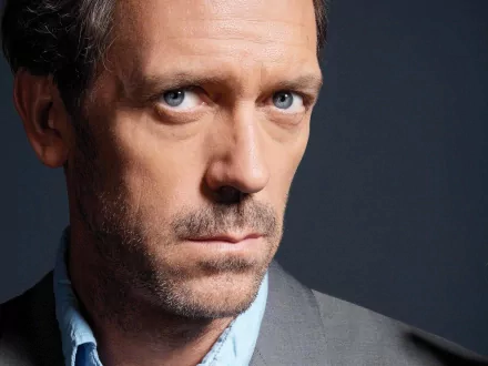Close-up HD desktop wallpaper of Hugh Laurie as Dr. Gregory House from the TV show House, featuring his intense expression against a dark background.