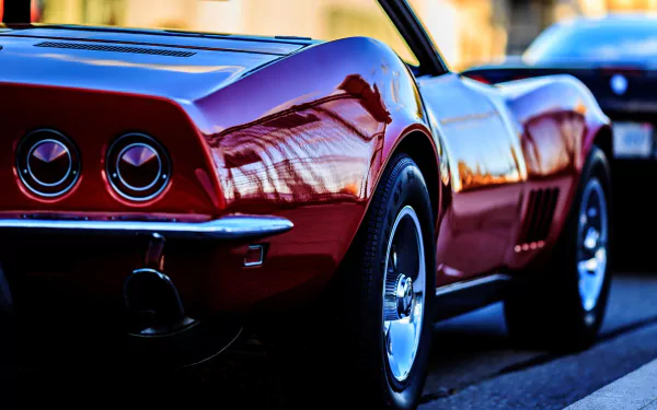 HD desktop wallpaper featuring a sleek red Chevrolet Corvette parked on a street, highlighting the car's classic design and polished finish.