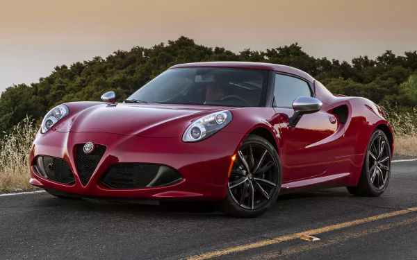 A striking Alfa Romeo 4C in a vibrant red hue, positioned on a scenic road, showcasing its sleek design and dynamic presence. Captured in stunning 4K Ultra HD quality.