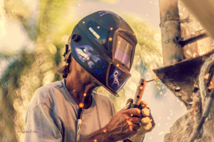 A welder wearing a protective helmet sparks bright welding in a bokeh-lit scene, captured in stunning 4K Ultra HD quality as a PC desktop wallpaper.