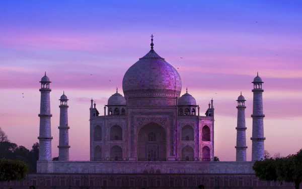 A stunning HD image of the Taj Mahal, showcasing its majestic architecture against a colorful twilight sky, serving as a captivating desktop wallpaper and background.