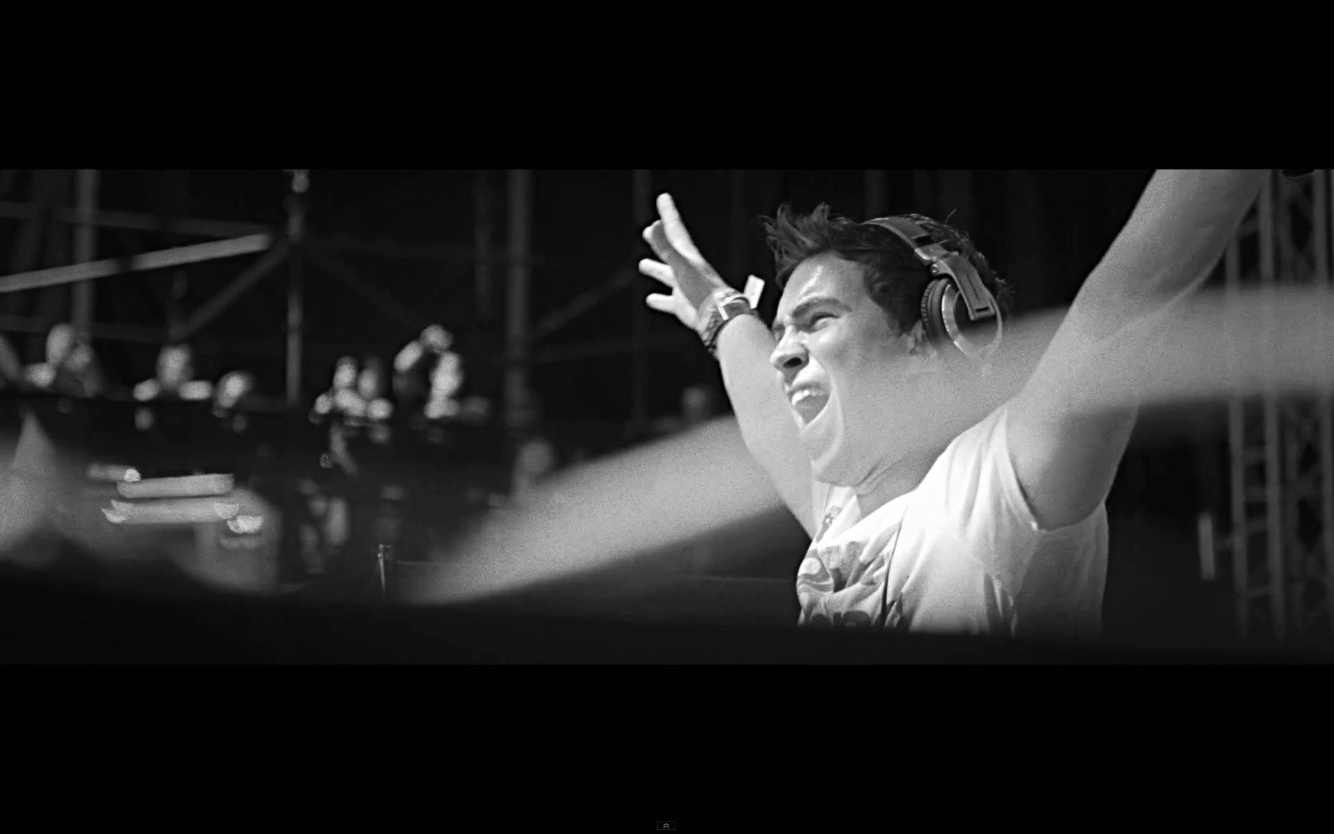 Black and white HD desktop wallpaper of DJ Hardwell performing live with arms raised, immersed in music.