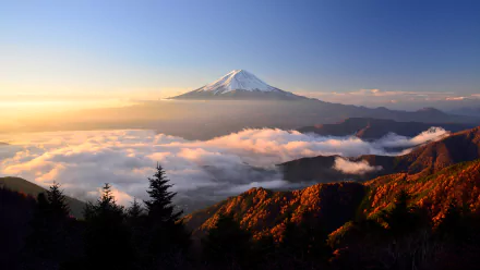 A stunning sunrise over Mount Fuji, showcasing the stratovolcano amidst a scenic landscape of clouds and autumn foliage, capturing the essence of Japan’s natural beauty.