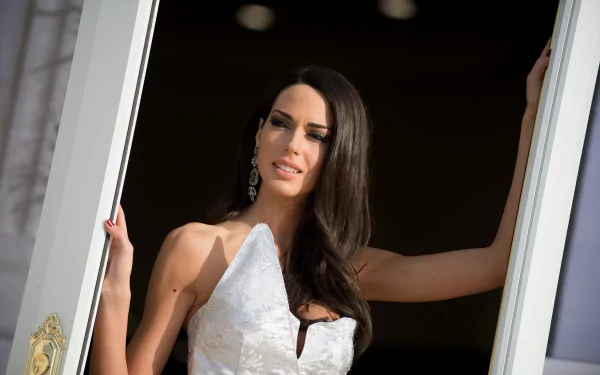 4K Ultra HD portrait of a model with long dark hair in an elegant white dress, posed in a doorway — PC desktop wallpaper.