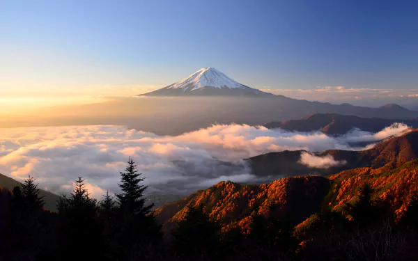 A stunning sunrise over Mount Fuji, showcasing the stratovolcano amidst a scenic landscape of clouds and autumn foliage, capturing the essence of Japan’s natural beauty.