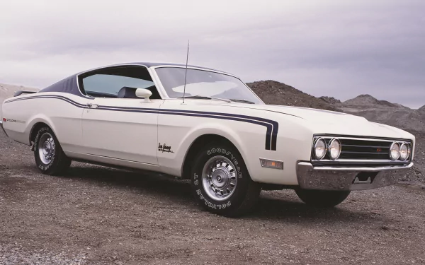 Classic white Mercury Cyclone coupe on gravel with overcast sky, showcased as a 2K Quad HD PC desktop wallpaper/background.