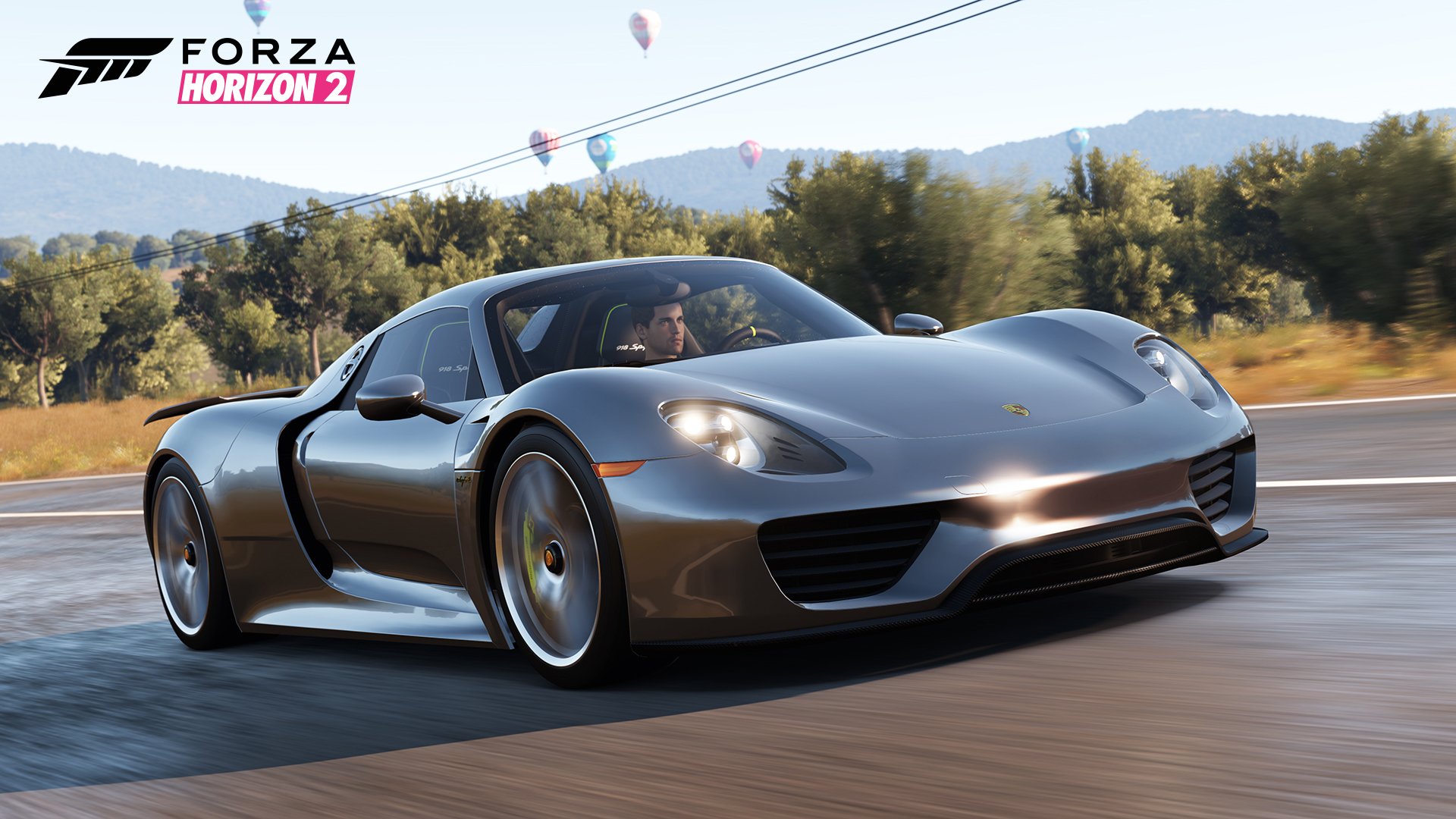 HD PC desktop wallpaper/background from the video game Forza Horizon 2: a silver supercar speeding along a sunlit road with trees, rolling hills and hot-air balloons in the sky.