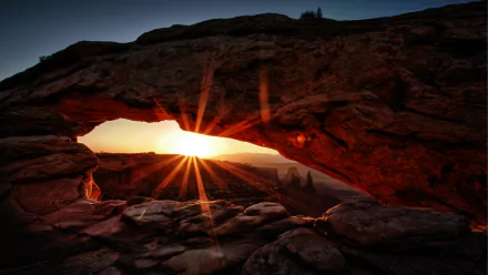 Sunrise through Mesa Arch framing desert spires, glowing orange rock and starburst sun - 5K Ultra HD PC desktop wallpaper/background