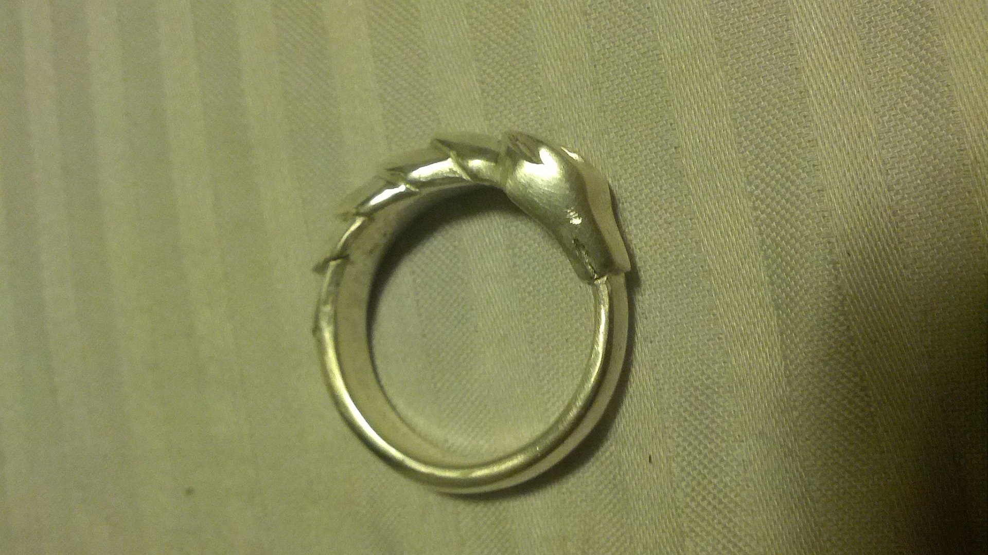 HD fantasy desktop wallpaper featuring a detailed ouroboros ring, symbolizing infinity with a serpent biting its own tail.