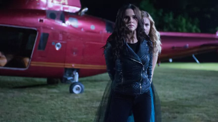 Vampire Academy movie 2K Quad HD PC wallpaper: two women stand tense before a red helicopter at night in a dramatic, low‑light action scene.