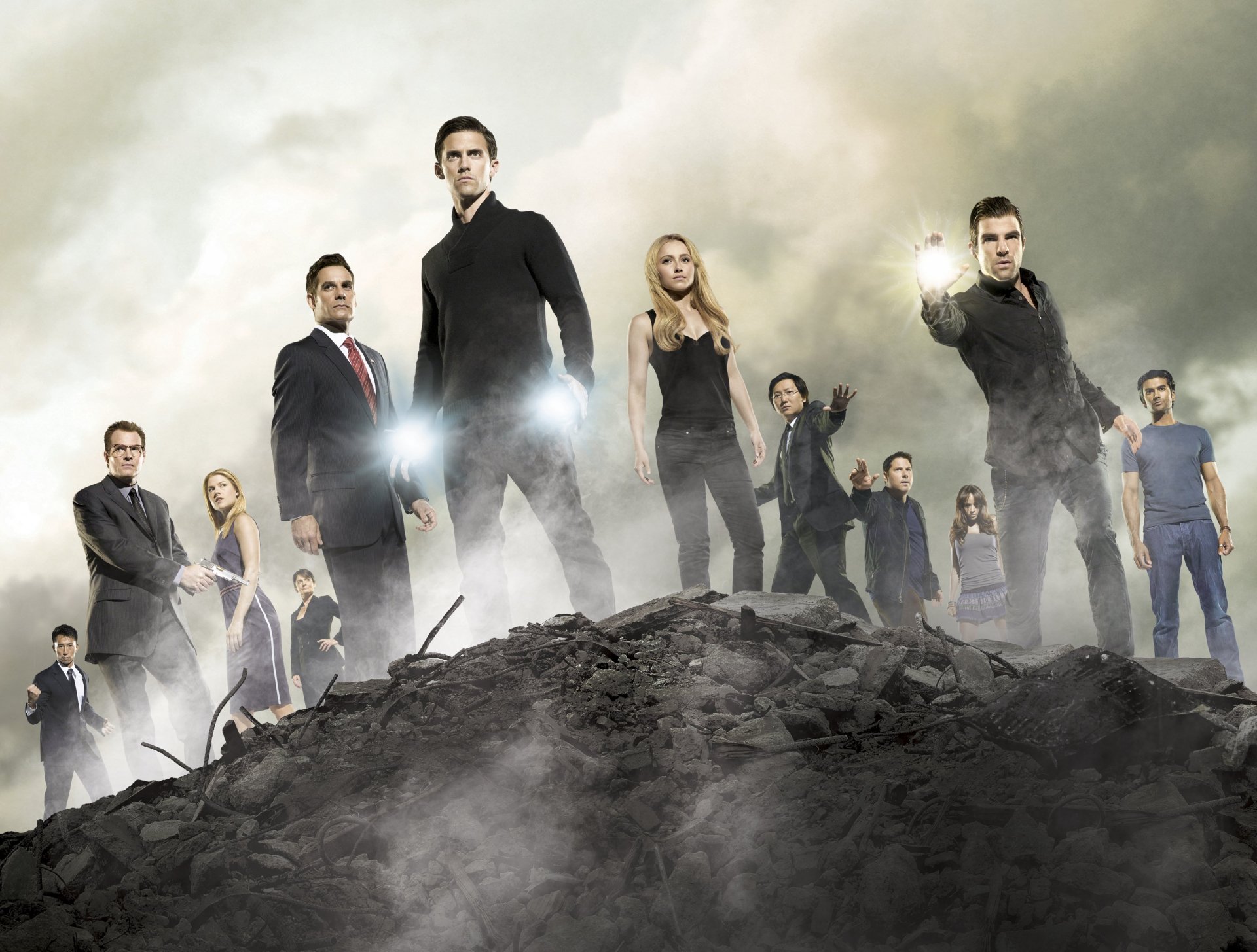 An HD desktop wallpaper featuring characters from the TV show Heroes, standing confidently on a rocky landscape with dramatic lighting and a sense of action and intrigue.