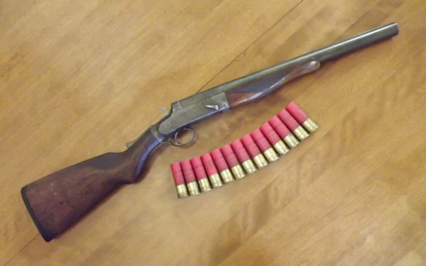 4K Ultra HD desktop wallpaper featuring a man-made shotgun with wooden stock and a row of red shotgun shells on a wooden surface.