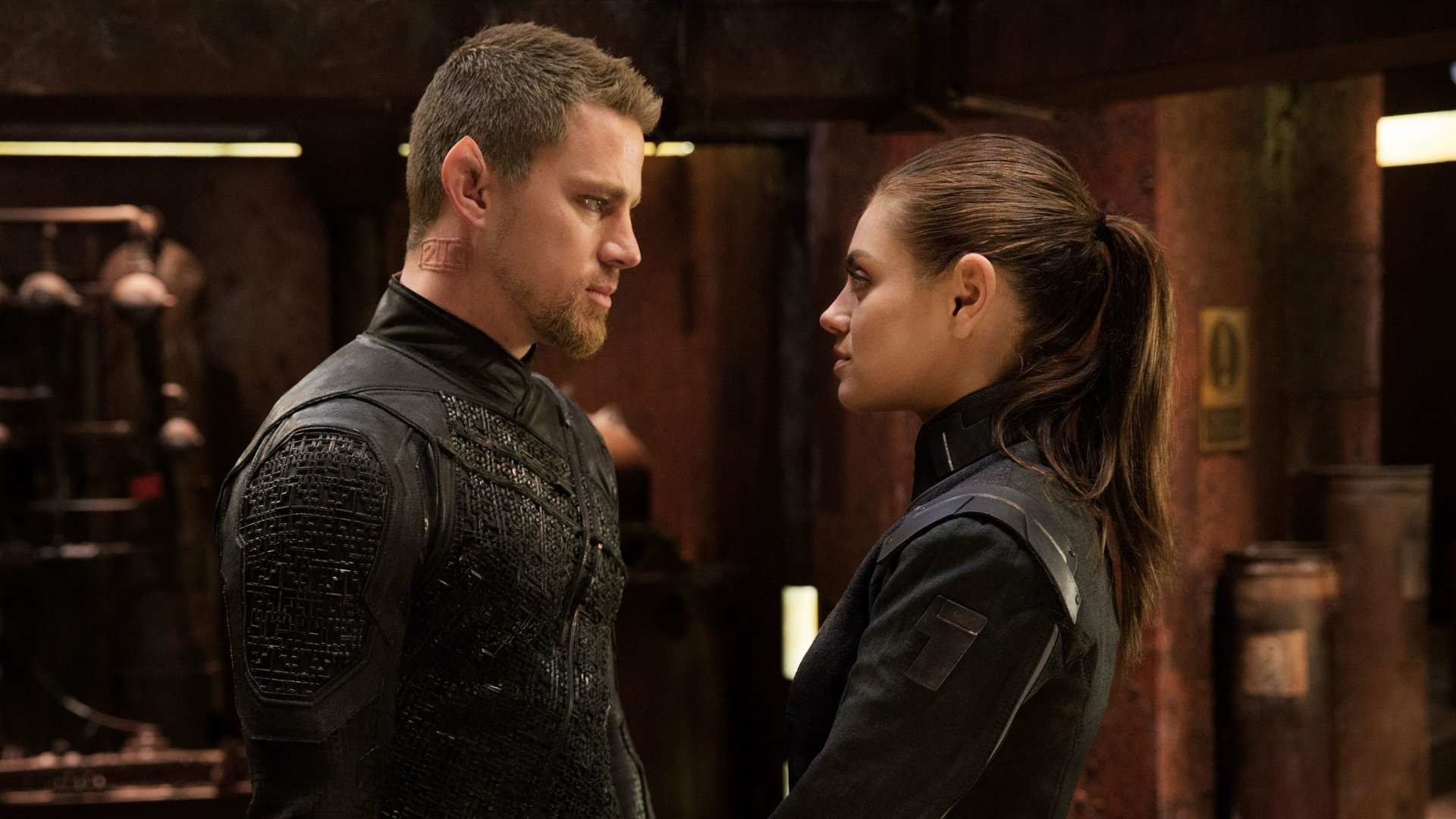 Channing Tatum and Mila Kunis face each other in a dark, intense scene from the movie Jupiter Ascending, featured as an HD PC desktop wallpaper.