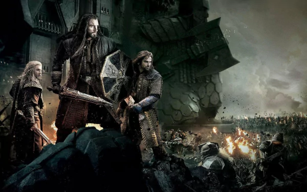 Movie HD PC desktop wallpaper: The Hobbit: The Battle of the Five Armies — armored warriors stand on a rocky ridge overlooking a fiery, smoke-choked battlefield under a stormy sky.