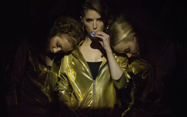 HD desktop wallpaper from the movie Pitch Perfect 2 featuring three women in gold jackets against a dark background.