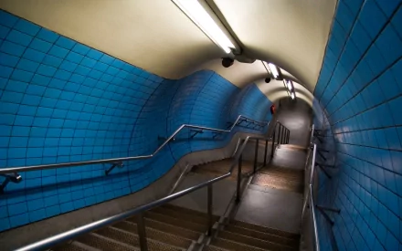 A vibrant blue-tiled tunnel with stairs and handrails, illuminated by overhead lights, creates a striking visual for a HD PC desktop wallpaper and background.