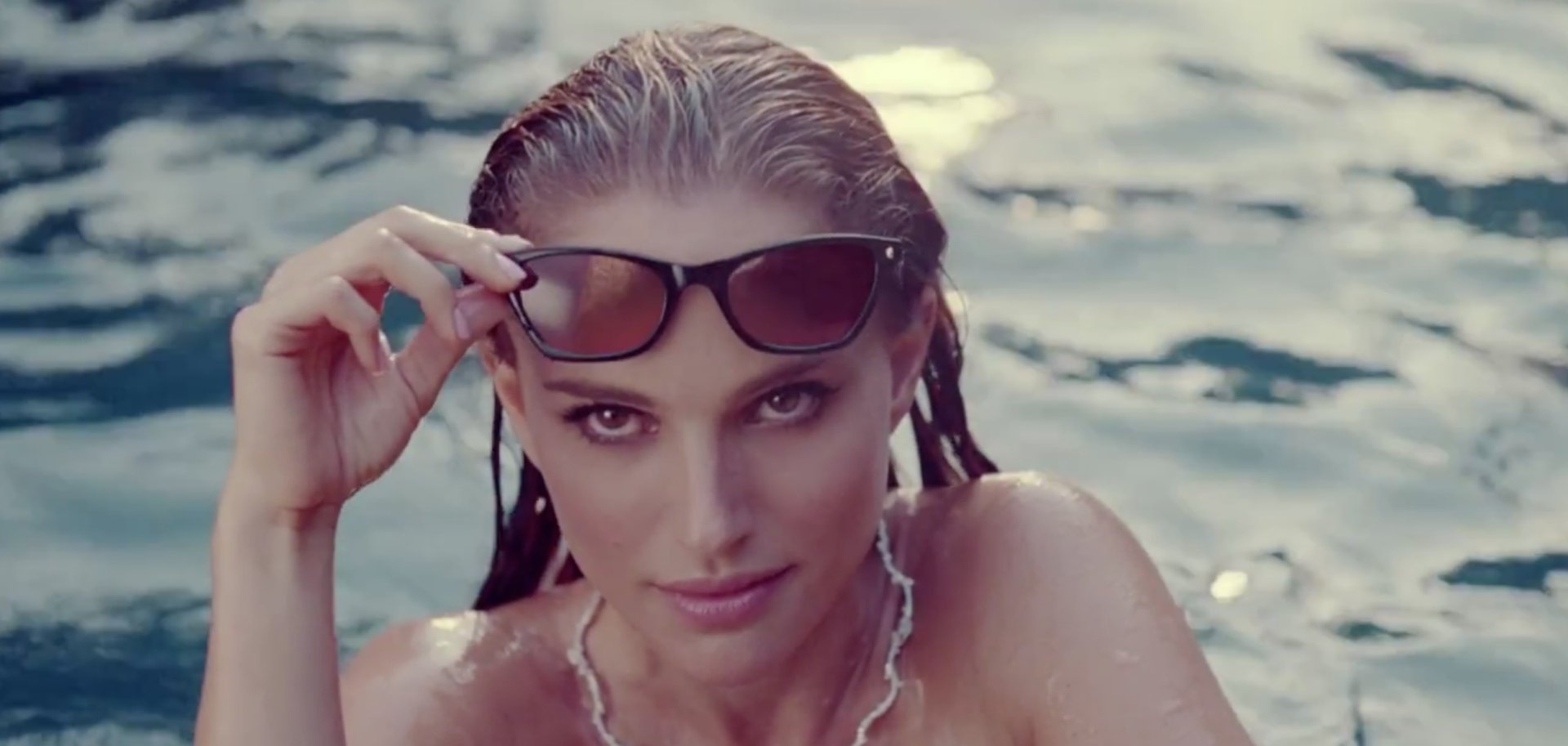 HD desktop wallpaper featuring celebrity Natalie Portman emerging from water, holding sunglasses above her eyes with a serene expression.