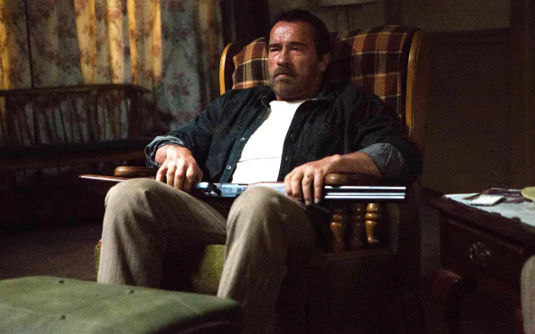 HD PC desktop wallpaper from the movie Maggie (2015): weary man in a plaid armchair holds a shotgun across his lap in a dim, cluttered living room.