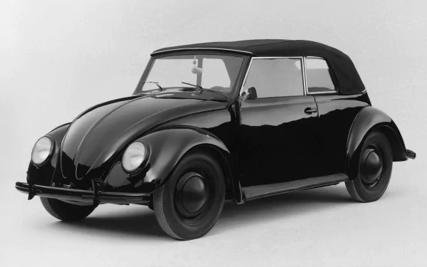 A classic black convertible vehicle, showcasing timeless design, set against a minimalist background. This HD desktop wallpaper brings vintage charm to your screen.